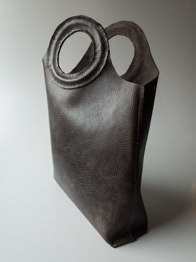 Brun lædertaske med runde håndtag, stilfuldt design. Perfekt til modeentusiaster og hverdagsbrug.
