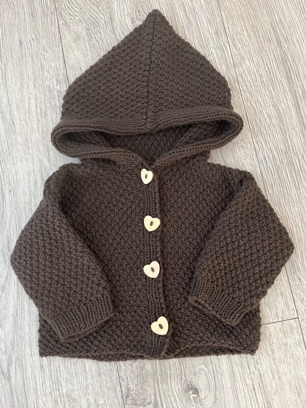 Brun babytrøje i strik med hætte og hjerteformede knapper, perfekt til kølige dage. Ideel til småbørns mode.