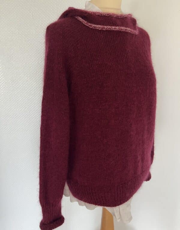 A cozy, deep burgundy hoodie/sweater with a rounded neckline, displayed on a mannequin over a light blouse.